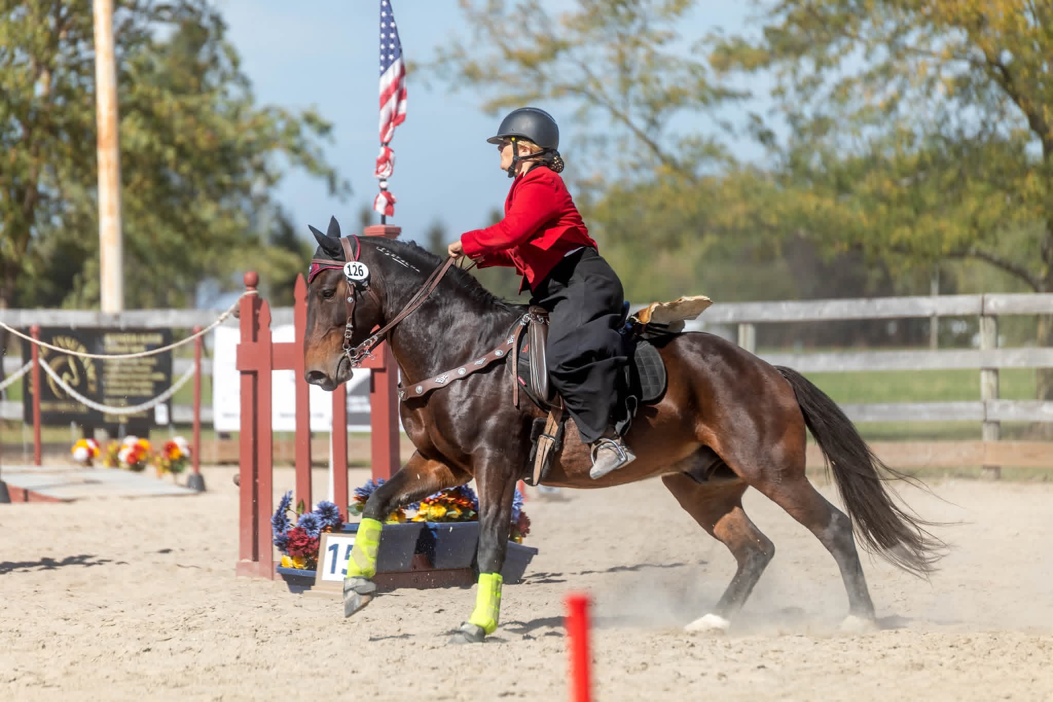 Rider Alex Tyson performing a working equitation obstacle on a bay horse in an outdoor arena.